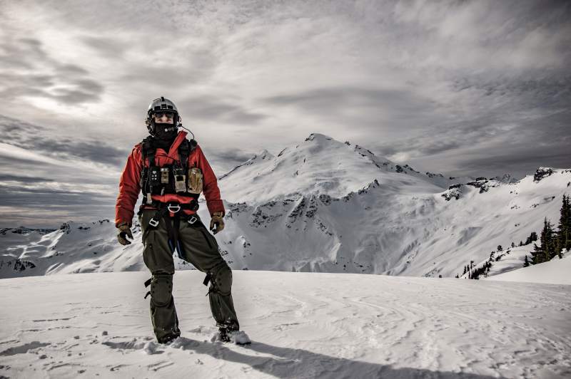 Navy pilot stands on snow covered mountain