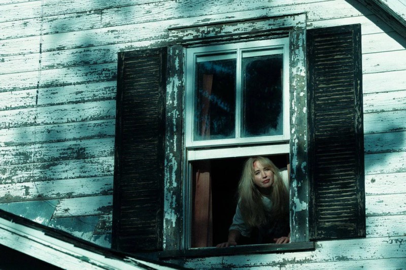 Grace looking out the window of the house in Die My Love